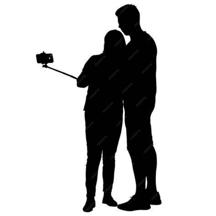 a man and woman taking a selfie in front of a television screen with