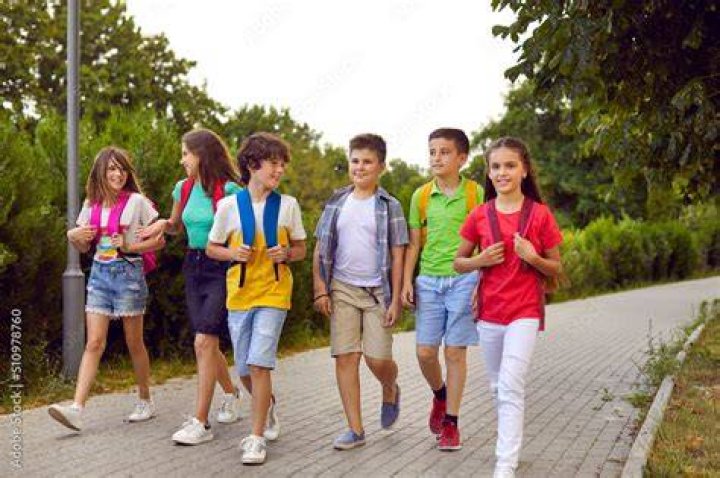 Happy school children to walk past a cafe 6635414 Vector Art at Vecteezy