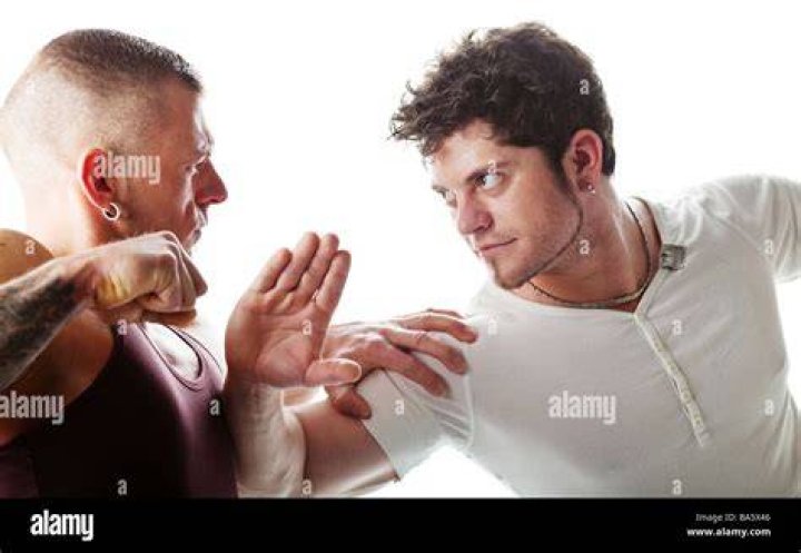 two men are fighting with each other outside